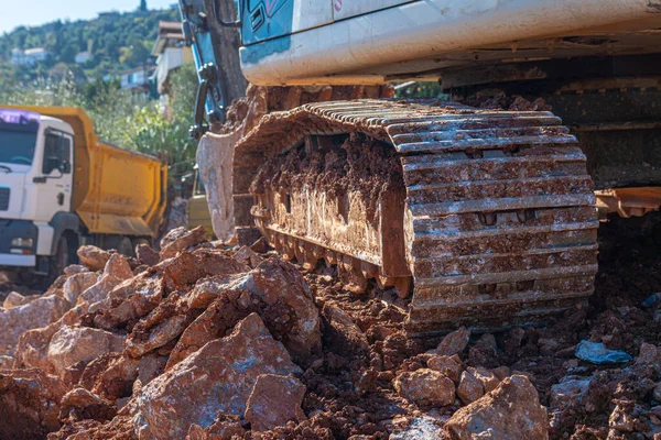 Heavy machinery works at the construction site. Clearing rocky soil for construction in Turkey. Crawler Excavator stands on the rocks.