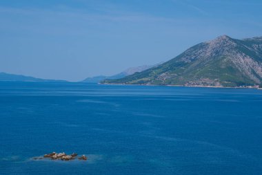 Güzel bir göl manzarası, çam ormanı ve vahşi plaj manzarası. Adriyatik Denizi 'nin muhteşem turkuaz suları, arka planda dağlar görülebilir..