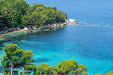Güzel bir göl manzarası, çam ormanı ve vahşi plaj manzarası. Adriyatik Denizi 'nin muhteşem turkuaz suları, arka planda dağlar görülebilir..