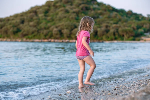 Meisje Spelen Het Zee Zandstrand Een Meisje Een Roze Shirt Stockafbeelding