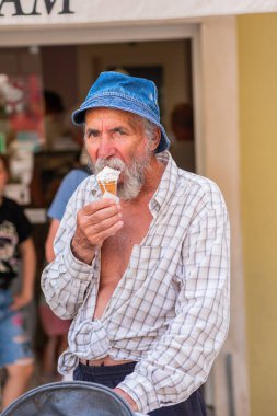 Elinde dondurma olan yakışıklı, yaşlı bir adam. Panama 'da sakallı yaşlı bir adam dondurma tutuyor ve gülümsüyor. Tatil köyünde güneşli bir gün.