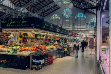 Valencia, İspanya 1.03.2024: Valencia Merkez Pazarı. Markette bir sürü insan var. Tedarikçiler çeşitli gıda ürünleri satar. İspanya 'da gıda pazarı.