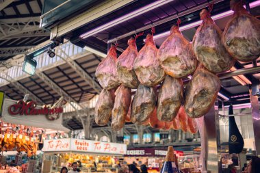 Valencia, İspanya 1.03.2024: Pazarda jamon satmak. Domuz budu şeklinde jambon tezgahta müşterileri bekliyor. İspanya 'nın ulusal ürünü.