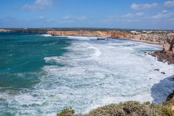 Öfkeli okyanusun güzel manzarası. Yüksek sarp kıyı kayalıkları, beyaz okyanus köpüğü ve yüksek dalgalar.