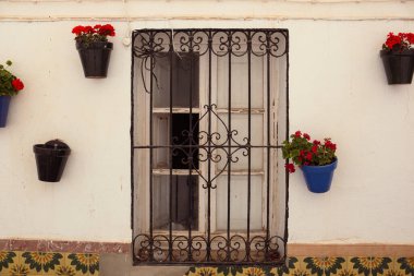 Eski bir evin duvarına sabitlenmiş seramik vazolardaki çiçekler. İspanya 'nın eski Nerja kasabasının dekoru..