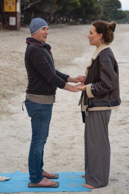 Genç kız akıl hocası, plajda hastasıyla çivi üstünde pratik yapıyor. Adam Sadhu tahtalarında duruyor. Adam akıl hocasıyla çivi üstünde pratik yapıyor. Bir rehber ile çivilerin üzerinde durmak ruhani bir alıştırmadır..