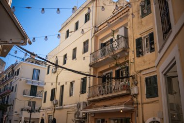 Yunanistan 'ın Korfu şehrinin caddesi. Eski kasaba, dar sokak, evlerin arasında asılı duran lamba çelenkleri..