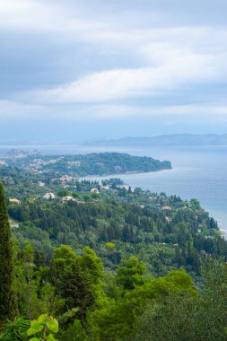 Korfu adasının güzel manzarası. Yeşil sahil ve deniz manzarası. Fırtınalı gökyüzü ve deniz üzerinde bulutlar.