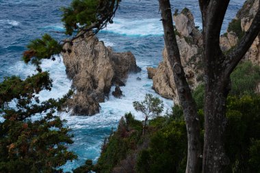 Açık denizde ıssız, küçük bir kayalık ada. Denizde fırtına, azgın dalgalar küçük adaya çarpıyor ve beyaz spreyle patlıyor. Fırtınalı bir denizde kayalar.