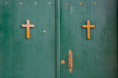 Green door of the monastery with Orthodox crosses. clipart