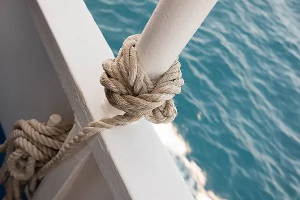 Bir halat, bir deniz gemisinin güvertesinde düğümlenir. Deniz düğümüne yakın çekim. Gemi halatı.