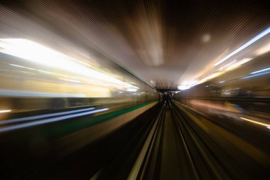 Metro tünelinin hareket bulanıklığı. Metro vagonundaki hareketli bulanık fotoğraf. Gelen tren, tünel ve istasyon ışıkları bulanık. Tünelden geçen metro treni, ön tren vagonunun manzarası..