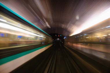Metro tünelinin hareket bulanıklığı. Metro vagonundaki hareketli bulanık fotoğraf. Gelen tren, tünel ve istasyon ışıkları bulanık. Tünelden geçen metro treni, ön tren vagonunun manzarası..
