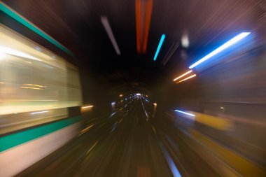 Metro tünelinin hareket bulanıklığı. Metro vagonundaki hareketli bulanık fotoğraf. Gelen tren, tünel ve istasyon ışıkları bulanık. Tünelden geçen metro treni, ön tren vagonunun manzarası..