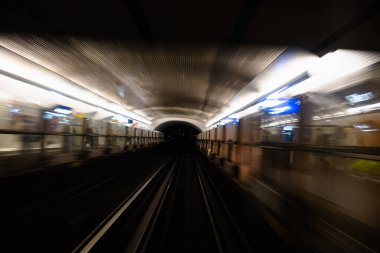 Metro tünelinin hareket bulanıklığı. Metro vagonundaki hareketli bulanık fotoğraf. Gelen tren, tünel ve istasyon ışıkları bulanık. Tünelden geçen metro treni, ön tren vagonunun manzarası..