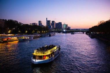 Paris, Fransa - 04.11.2024: Paris 'teki Seine Nehri, gün batımında nehir boyunca yelken açan bir turist gemisi. Paris 'in Panoraması ve Seine Nehri.