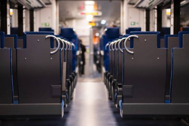 Bir yolcu vagonunda. Boş bir bölgesel yolcu treninin simetrik fotoğrafı olan uzun sıra sıra koltuklar mesafeye uzanıyor. Alman bölgesel yolcu treni, iç görünüm.