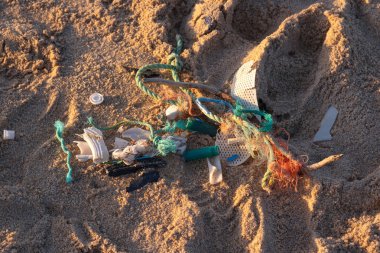 Plastik çöpler plajda. Plastikle çevre kirliliği. Okyanus kıyısı atıkla kirlenmiş. Yakın plan fotoğraf..