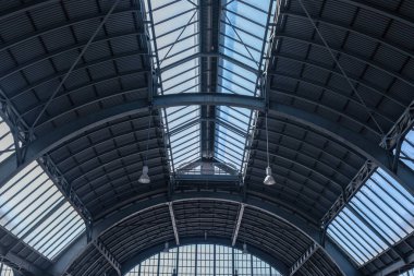 Bir Alman şehrindeki büyük bir tren istasyonunun çatısı. Almanya 'daki bir tren istasyonunun çatı katı manzarası. Fenerler asıldı, metal yapı ve üst ve yan taraflarda geniş pencereler var..