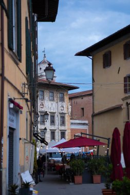 Akşamları İtalyan şehrinin caddesi. Fener, arka planda kilise, kafe şemsiyeler. Akşamları eski İtalyan şehri.