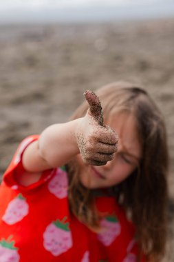 Kırmızı tişörtlü güzel küçük kız kameraya bakıyor, 