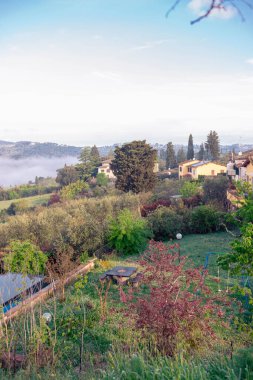 Sis dağların arasından sabahın erken saatlerinde Toskana köyündeki bir nehir gibi akar. İtalya 'nın Toskana bölgesinde resim gibi bir manzara. Tepeler, selvi ağaçları, üzüm bağları..