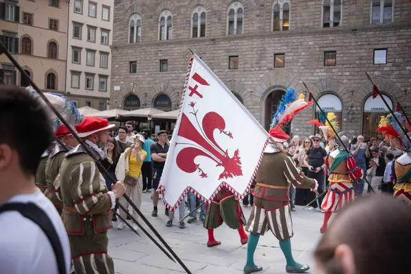 Floransa, İtalya, 04.16.2025: Bir İtalyan şehrinin ortasında şövalye alayı. Floransa 'da bir meydanda bayraklı, tarihi kostümlü bir geçit töreni yapılıyor..