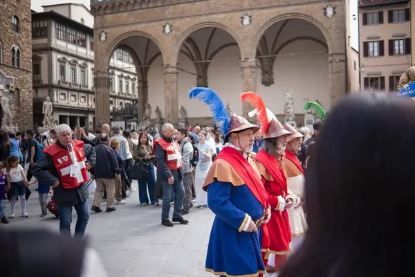Floransa, İtalya, 04.16.2025: Bir İtalyan şehrinin ortasında şövalye alayı. Floransa 'da bir meydanda bayraklı, tarihi kostümlü bir geçit töreni yapılıyor..