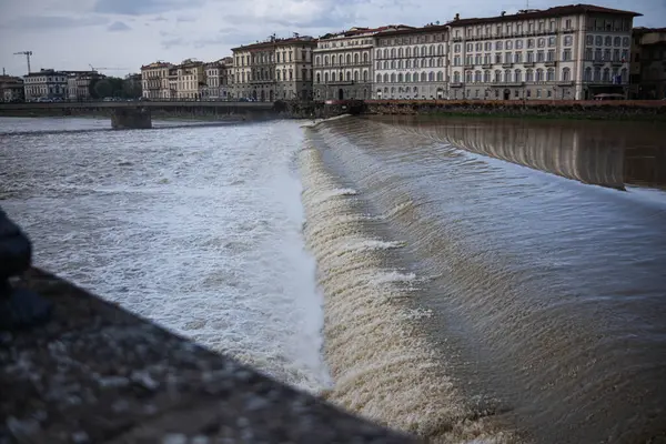 İtalya, Floransa 'da çalkantılı, taşan bir nehir. Suyun akıntıya karışması köpük ve sprey oluşturur..