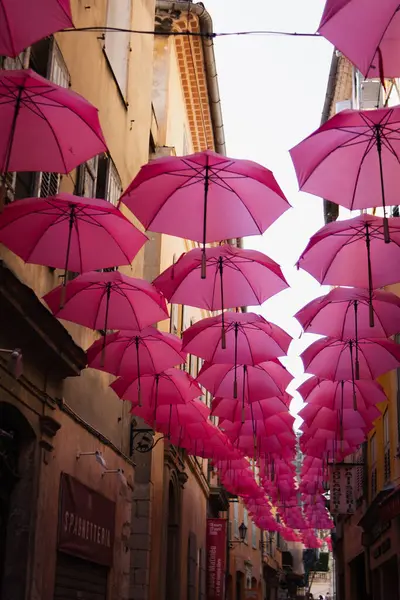 Bir İtalyan şehrinde güzel dar bir cadde. Cadde kırmızı şemsiyelerle süslenmiştir. Gölge ve güzellik yaratmak için birçok şemsiye en üste asılır..