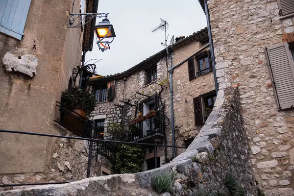 Eski kasaba, taş bina, Çin salkımının taştan duvarlarda büyümesi ve bol bol mor çiçeklerle açması. Fransa 'nın Vence kentinin manzarası.