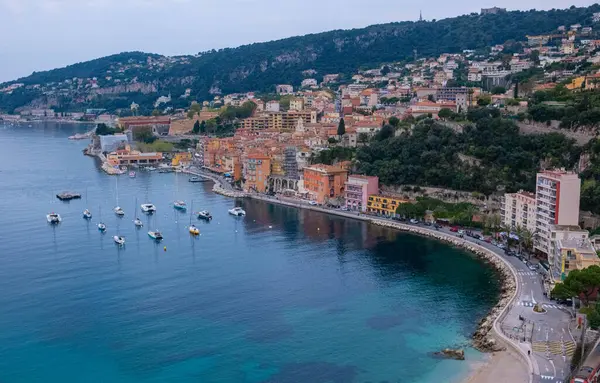 Fransa 'nın deniz kıyısındaki tatil köyünün panoramik manzarası. Villefranche-sur-Mer, kayıklar ve denizin berrak mavi kristal suyuyla doldur. Yükseklerden deniz kenarı manzarası.