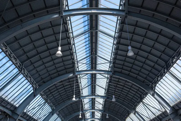 Bir Alman şehrindeki büyük bir tren istasyonunun çatısı. Almanya 'daki bir tren istasyonunun çatı katı manzarası. Fenerler asıldı, metal yapı ve üst ve yan taraflarda geniş pencereler var..