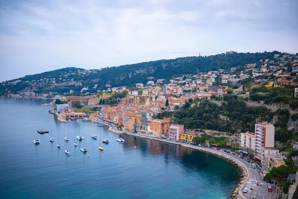 Fransa 'nın deniz kıyısındaki tatil köyünün panoramik manzarası. Villefranche-sur-Mer, kayıklar ve denizin berrak mavi kristal suyuyla doldur. Yükseklerden deniz kenarı manzarası.