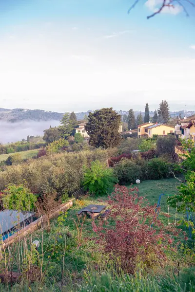 Sis dağların arasından sabahın erken saatlerinde Toskana köyündeki bir nehir gibi akar. İtalya 'nın Toskana bölgesinde resim gibi bir manzara. Tepeler, selvi ağaçları, üzüm bağları..