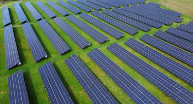 Yenilenebilir enerji üreten birçok sıra fotovoltaik panele sahip büyük bir güneş enerjisi çiftliği. Güneş enerjisi, çevre dostu elektrik üretimi. Yeşil enerji, güneş teknolojisi, temiz enerji. 