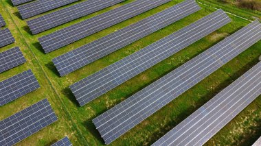 Yenilenebilir enerji üreten birçok sıra fotovoltaik panele sahip büyük bir güneş enerjisi çiftliği. Güneş enerjisi, çevre dostu elektrik üretimi. Yeşil enerji, güneş teknolojisi, temiz enerji. 