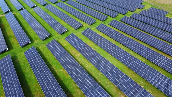 Yenilenebilir enerji üreten birçok sıra fotovoltaik panele sahip büyük bir güneş enerjisi çiftliği. Güneş enerjisi, çevre dostu elektrik üretimi. Yeşil enerji, güneş teknolojisi, temiz enerji. 