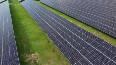 Hava manzarası, geniş güneş çiftliği yenilenebilir enerjiyi kullanan fotovoltaik paneller sergiliyor. Temiz ve sürdürülebilir elektrik üretiminde güneş enerjisi teknolojisi. Çevre dostu altyapı. Düşük karbonlu gelecek, enerji verimliliği. 