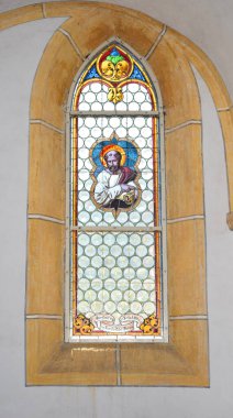Hristiyanlığın önemli bir habercisi olan Aziz Peter 'ı tasvir eden lekeli cam kilise penceresi. El yapımı sanat eserlerinde, tipik bir ortaçağ Gotik mimarisi olan taştan bir çerçevede zengin ikonografi ve renkli camlar yer alıyor. Geleneksel Avrupa Şapeli.