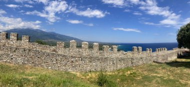 Tarihi mimarisi olan antik bir kalenin bir parçası olan Ortaçağ Yunan Platamon kale duvarı. Dağ manzarası, deniz manzarası ve Ege Denizi kıyısı. Kale manzarası, mavi gökyüzü, okyanus manzarası..