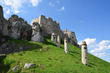 Orta Avrupa 'nın en büyük ortaçağ kaleleri olan Spis Kalesi' nin kalıntıları Slovak dağlıklarında yeşil bir tepenin üzerinde yer alıyor. Taş duvarlar ve siperler zengin tarihi, mimariyi ve mirası yansıtıyor. Yeşil çimenler ve bulutlu yaz gökyüzü. 