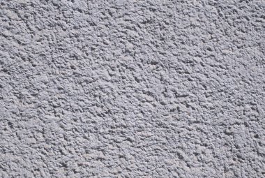 Gri bir duvarın arka planının kabataslak, kumlu bir dokusu var. Beton yüzey doğal düzensizlikleri gösteriyor, bu da onu arka planlar, mimari sunumlar veya inşaatla ilgili tasarım projeleri için ideal kılıyor.. 
