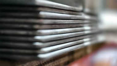 Üst üste yığılmış metal plakaların detaylı yakın plan görüntüleri bulanık arka plan, gösterişli doku ve endüstriyel his