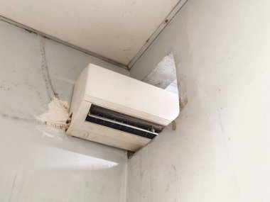 Verimli uzay kullanımını gösteren, ortak bir havalandırma deliğinden iki odayı soğutmak için duvara monte edilmiş bir klima.