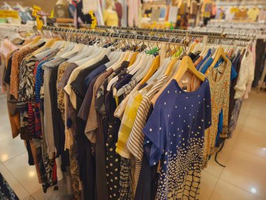 Düzenli ve sağlam tasarımlar da dahil olmak üzere çeşitli kıyafetler. Geleneksel bir market giyim mağazasında raflara asılmış. Yüksek kalite fotoğraf