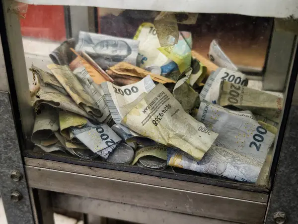 Bogor, Endonezya - 18 Mayıs 2025: Bağış kutusuna yığılmış bir yığın banknot, hayırseverliği ve cömertliği simgeliyor