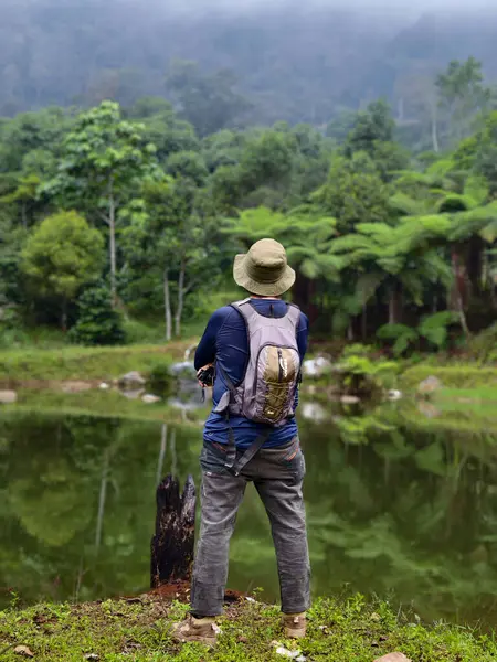 Bogor, Endonezya - 29 Mayıs 2025: Sırt çantalı Maceraperest Adam Serene Dağı Gölü 'ne bakıyor