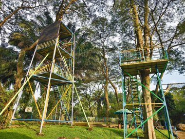 Parktaki yemyeşil ağaçların arasında renkli destekli çok katmanlı Uçan Tilki Fırlatma Kulesi. Yüksek kalite fotoğraf