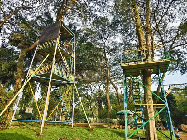 Parktaki yemyeşil ağaçların arasında renkli destekli çok katmanlı Uçan Tilki Fırlatma Kulesi. Yüksek kalite fotoğraf